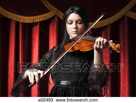 Stock Image - Young woman playing violin. Fotosearch