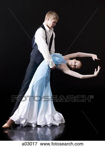 Stock Photo - Young woman posing with teenage boy (16-17) as two professional dancers, studio shot. Fotosearch