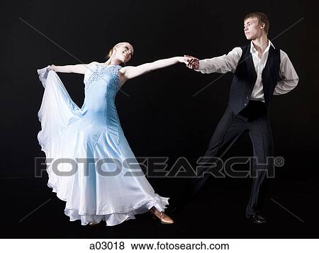 Stock Photo - Young woman posing with teenage boy (16-17) as two professional dancers, studio shot. Fotosearch