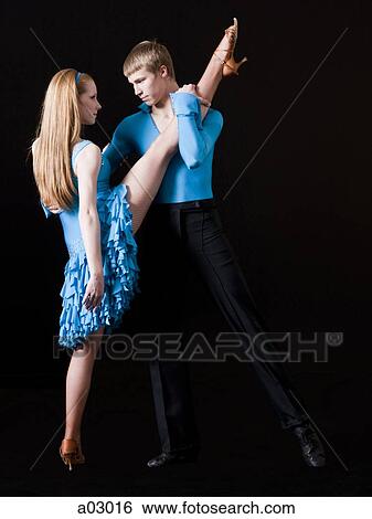 Stock Photograph - Young woman posing with teenage boy (16-17) as two professional dancers, studio shot. Fotosearch