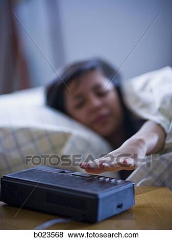 young woman reaching for alarm clock View Large Photo Image Stock Photo - young woman reaching for alarm clock. Fotosearch
