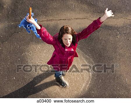 Young woman standing in rain with arms outstretched View Large Photo Image Stock Image - Young woman standing in rain with arms outstretched. Fotosearch