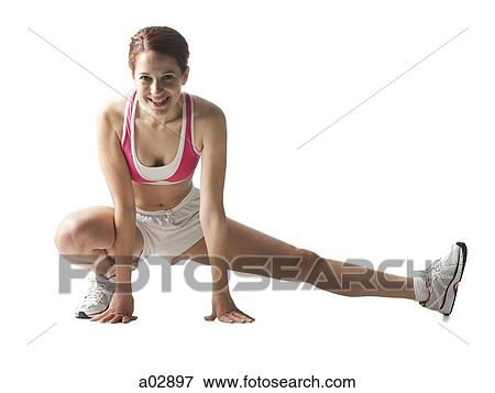 Young woman stretching, studio shot View Large Photo Image Stock Photo - Young woman stretching, studio shot. Fotosearch