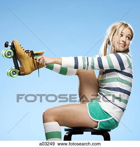 Young woman wearing roller skates, studio shot View Large Photo Image Stock Photo - Young woman wearing roller skates, studio shot. Fotosearch
