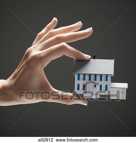 Young woman's hand holding toy house View Large Photo Image Stock Image - Young woman's hand holding toy house. Fotosearch
