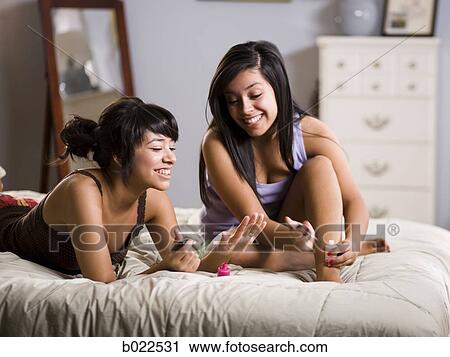 Stock Image - young women doing their nails. Fotosearch