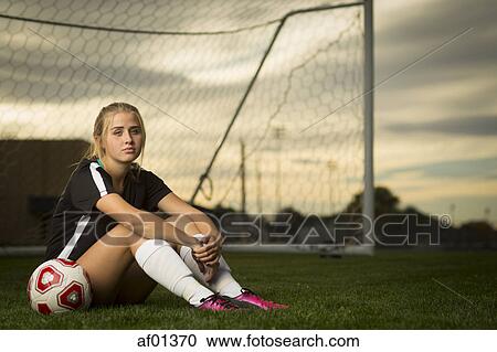 Athlete sitting with ball in soccer goal under sunset sky View Large Photo Image Stock Image - Athlete sitting with ball in soccer goal under sunset sky. Fotosearch
