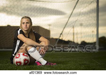 Athlete sitting with ball in soccer goal under sunset sky View Large Photo Image Stock Photo - Athlete sitting with ball in soccer goal under sunset sky. Fotosearch