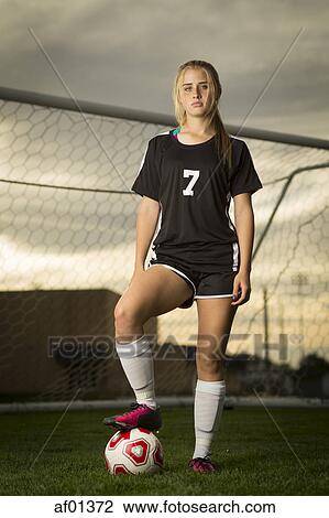Athlete standing with ball in soccer goal under sunset sky View Large Photo Image Stock Image - Athlete standing with ball in soccer goal under sunset sky. Fotosearch