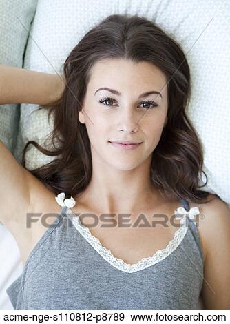 Stock Photo - Attractive young woman posing in bed. Fotosearch