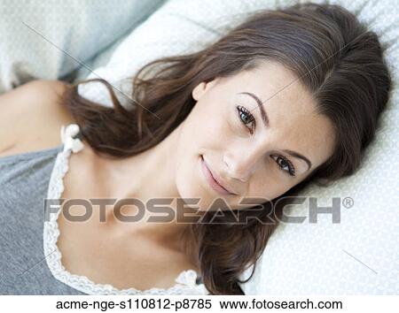 Stock Photography - Attractive young woman posing in bed. Fotosearch