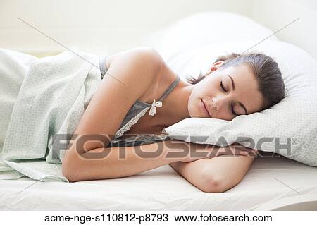 Attractive young woman sleeping in bed View Large Photo Image Stock Image - Attractive young woman sleeping in bed. Fotosearch