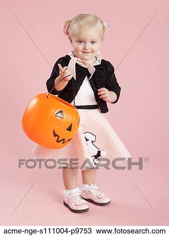 Baby girl (12-17 months) in 1950s style costume, holding pumpkin lantern for Halloween View Large Photo Image Stock Image - Baby girl (12-17 months) in 1950s style costume, holding pumpkin lantern for Halloween. Fotosearch