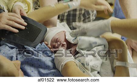 Blurred high angle view of doctors' hands cleaning newborn baby on mother in hospital View Large Photo Image Stock Image - Blurred high angle view of doctors' hands cleaning newborn baby on mother in hospital. Fotosearch