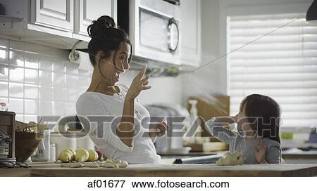 Blurred playful mother and daughter baking and tossing dough in kitchen View Large Photo Image Stock Photo - Blurred playful mother and daughter baking and tossing dough in kitchen. Fotosearch