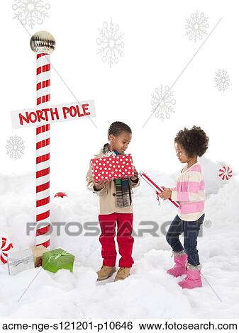 Boy (4-5) and girl (4-5) standing next to North Pole sign View Large Photo Image Stock Photograph - Boy (4-5) and girl (4-5) standing next to North Pole sign. Fotosearch