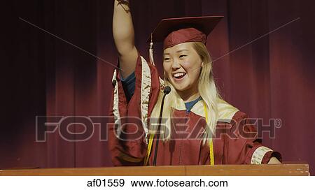 Cheering student speaking at podium on stage during graduation ceremony View Large Photo Image Stock Photo - Cheering student speaking at podium on stage during graduation ceremony. Fotosearch