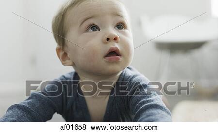 Close up of adorable inquisitive baby boy looking up View Large Photo Image Stock Photo - Close up of adorable inquisitive baby boy looking up. Fotosearch