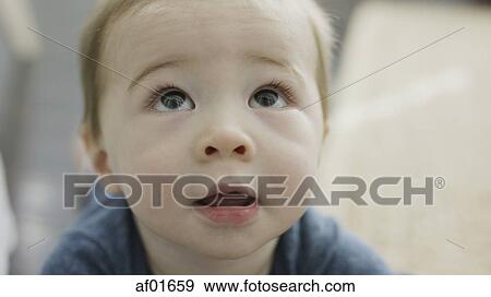 Close up of adorable inquisitive baby boy looking up View Large Photo Image Stock Photo - Close up of adorable inquisitive baby boy looking up. Fotosearch
