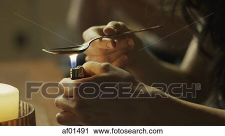 Close up of drug addict cooking drugs in spoon with lighter on dingy sofa View Large Photo Image Stock Image - Close up of drug addict cooking drugs in spoon with lighter on dingy sofa. Fotosearch