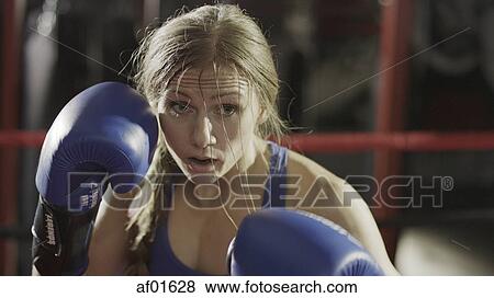 Close up of female boxer in boxing gloves standing in boxing ring during match View Large Photo Image Stock Photo - Close up of female boxer in boxing gloves standing in boxing ring during match. Fotosearch