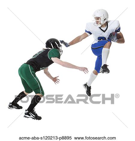 Stock Photography - Close up of two young players of American football fighting for ball, studio shot. Fotosearch