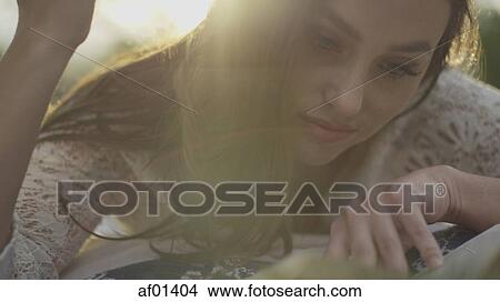 Close up portrait of curious woman reading outdoors View Large Photo Image Picture - Close up portrait of curious woman reading outdoors. Fotosearch