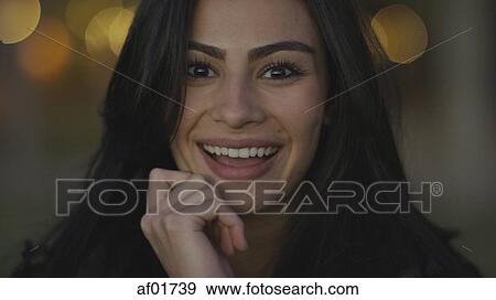 Stock Photo - Close up portrait of smiling woman touching her chin. Fotosearch