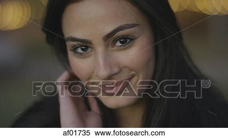 Close up portrait of smiling woman with long brown hair tucking hair behind ear View Large Photo Image Stock Photography - Close up portrait of smiling woman with long brown hair tucking hair behind ear. Fotosearch