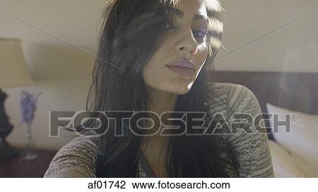 Close up portrait of sultry woman sitting on bed View Large Photo Image Stock Image - Close up portrait of sultry woman sitting on bed. Fotosearch