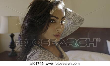 Close up portrait of sultry woman posing and sitting on bed View Large Photo Image Stock Photography - Close up portrait of sultry woman posing and sitting on bed. Fotosearch