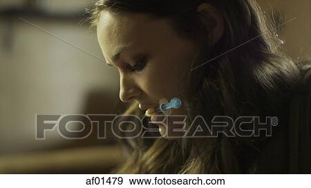Close up profile of drug addict holding syringe needle in mouth View Large Photo Image Stock Photo - Close up profile of drug addict holding syringe needle in mouth. Fotosearch