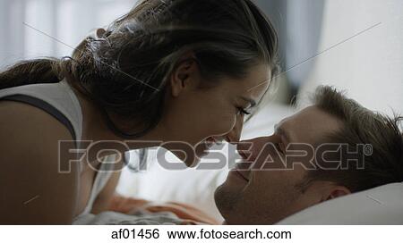 Close up profile of smiling happy couple touching noses on bed View Large Photo Image Stock Photograph - Close up profile of smiling happy couple touching noses on bed. Fotosearch