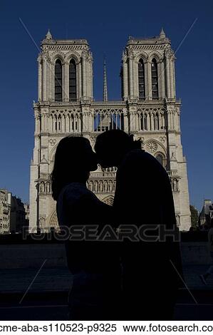 Stock Photography - France, Paris, Notre Dame de Paris, Young couple kissing. Fotosearch