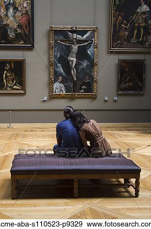 Stock Photo - France, Paris, The Louvre, Young couple looking at Christ on the Cross Adored by Donors by El Greco. Fotosearch
