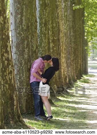 Stock Image - France, Paris, Young couple kissing in Versailles Park. Fotosearch