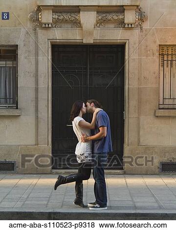 Stock Photo - France, Paris, Young couple kissing in street. Fotosearch