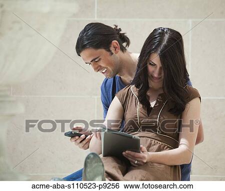 Stock Photograph - France, Paris, Young couple sitting in Louvre Museum. Fotosearch