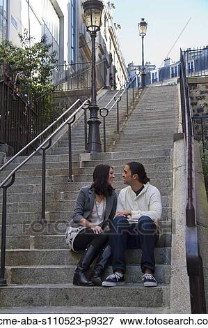 Stock Photo - France, Paris, Young couple sitting on steps. Fotosearch