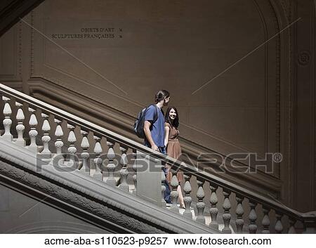 Stock Photo - France, Paris, Young couple walking on steps in Louvre Museum. Fotosearch
