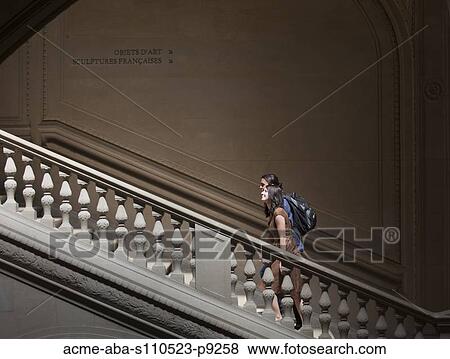 Stock Photo - France, Paris, Young couple walking on steps in Louvre Museum. Fotosearch