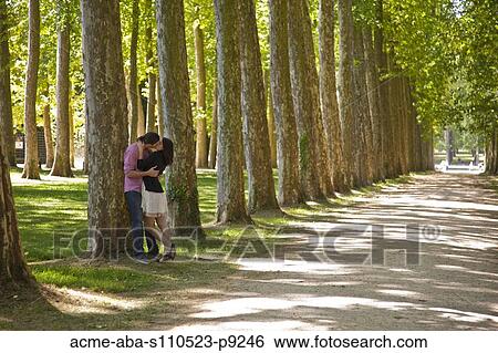 Stock Photograph - France, Versailles, Couple kissing in park. Fotosearch