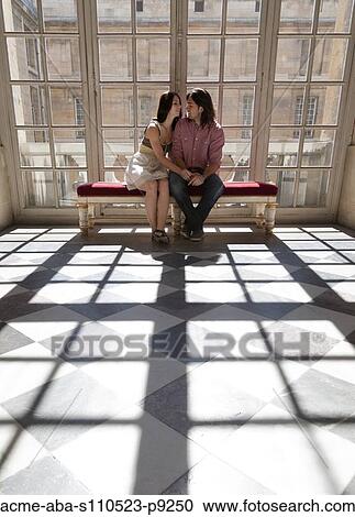 Stock Image - France, Versailles, Couple sitting in palace hall. Fotosearch