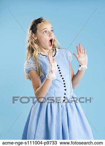 Stock Image - Girl (10-11) in Alice in Wonderland costume for Halloween. Fotosearch