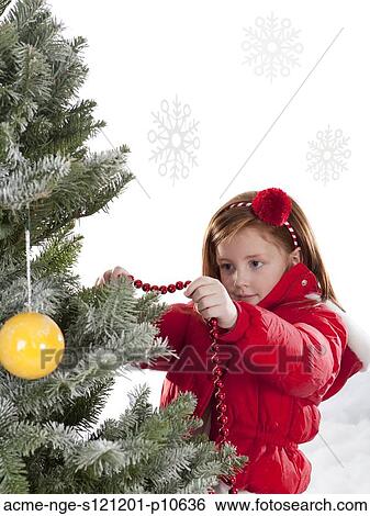 Girl (4-5) decorating Christmas tree View Large Photo Image Stock Photograph - Girl (4-5) decorating Christmas tree. Fotosearch