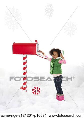 Stock Image - Girl (4-5) sending letter to Santa. Fotosearch