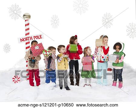 Group of kids (18-23months, 2-3, 4-5, 6-7) standing next to North Pole sign View Large Photo Image Stock Image - Group of kids (18-23months, 2-3, 4-5, 6-7) standing next to North Pole sign. Fotosearch