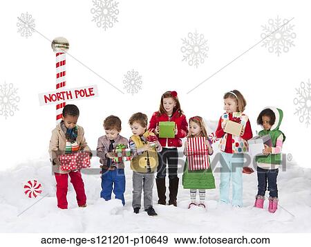 Group of kids (18-23months, 2-3, 4-5, 6-7) standing next to North Pole sign View Large Photo Image Stock Photo - Group of kids (18-23months, 2-3, 4-5, 6-7) standing next to North Pole sign. Fotosearch