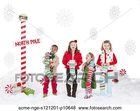 Group of kids (18-23months, 4-5, 6-7) standing next to North Pole sign View Large Photo Image Stock Photo - Group of kids (18-23months, 4-5, 6-7) standing next to North Pole sign. Fotosearch