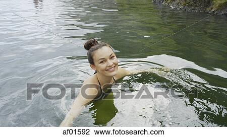 High angle portrait of smiling woman in bikini swimming in remote pool of water View Large Photo Image Stock Image - High angle portrait of smiling woman in bikini swimming in remote pool of water. Fotosearch